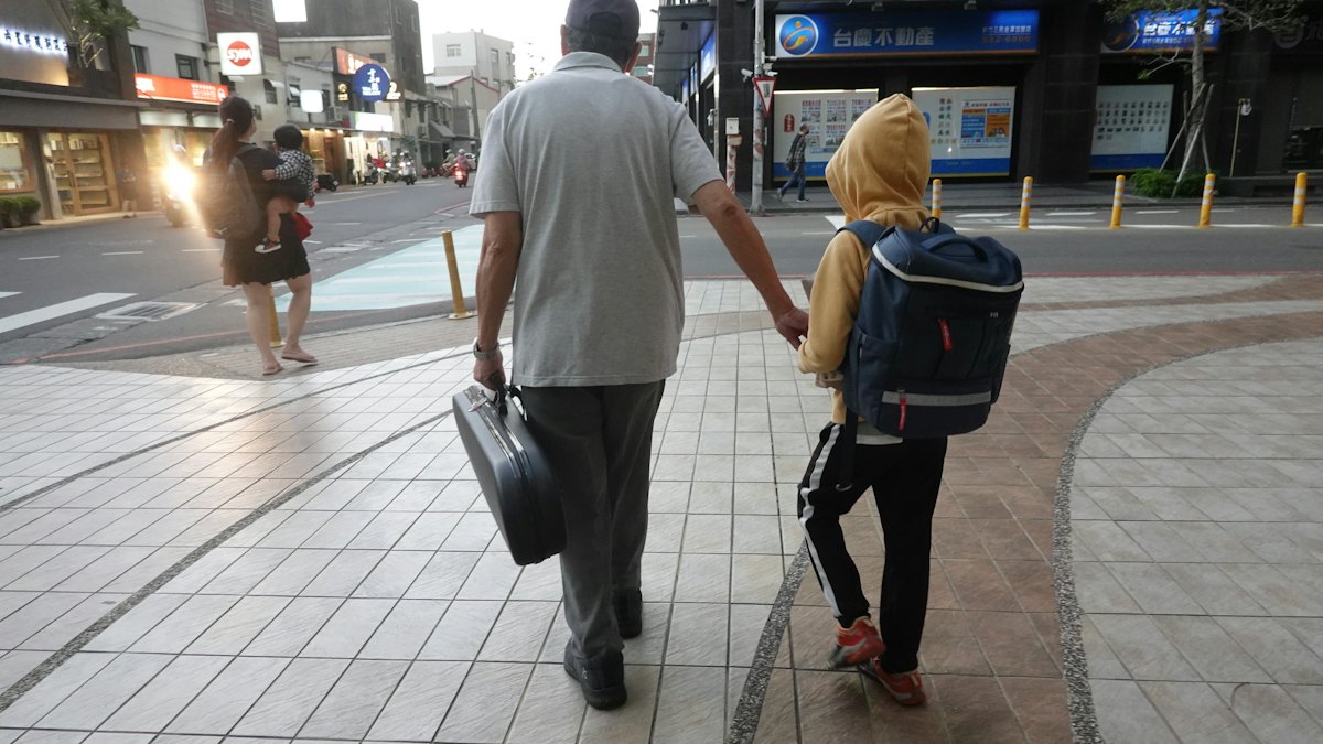 Padre y niño caminando de la mano por la calle