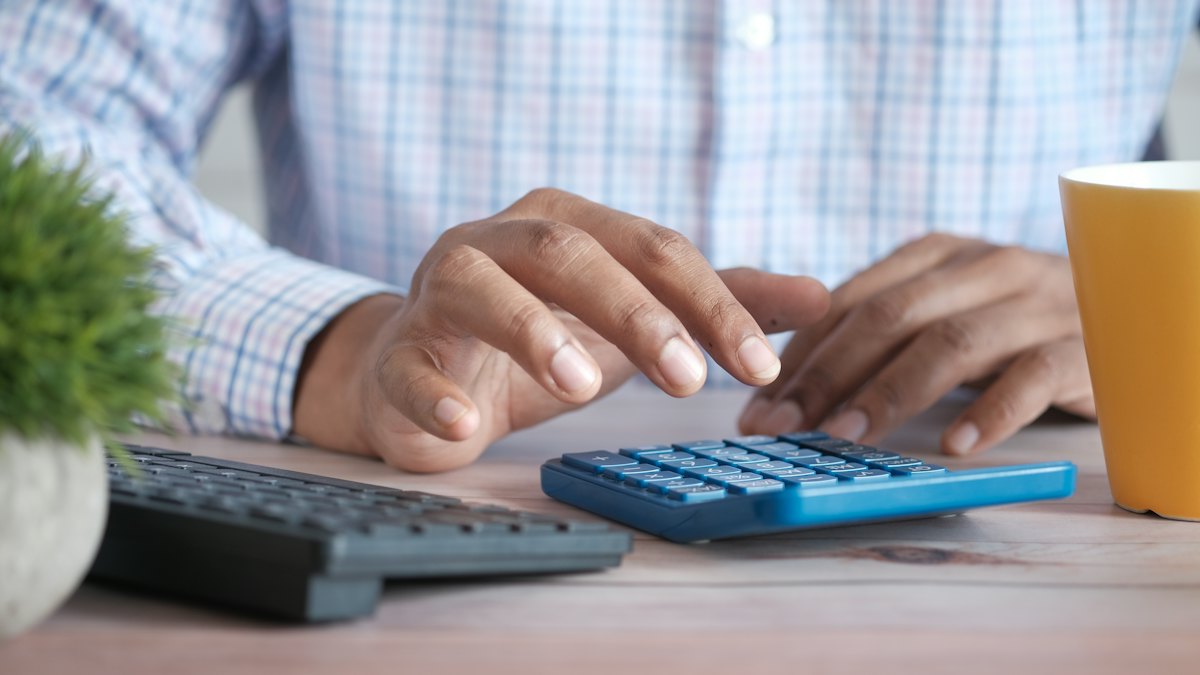 Persona haciendo cuentas con una calculadora